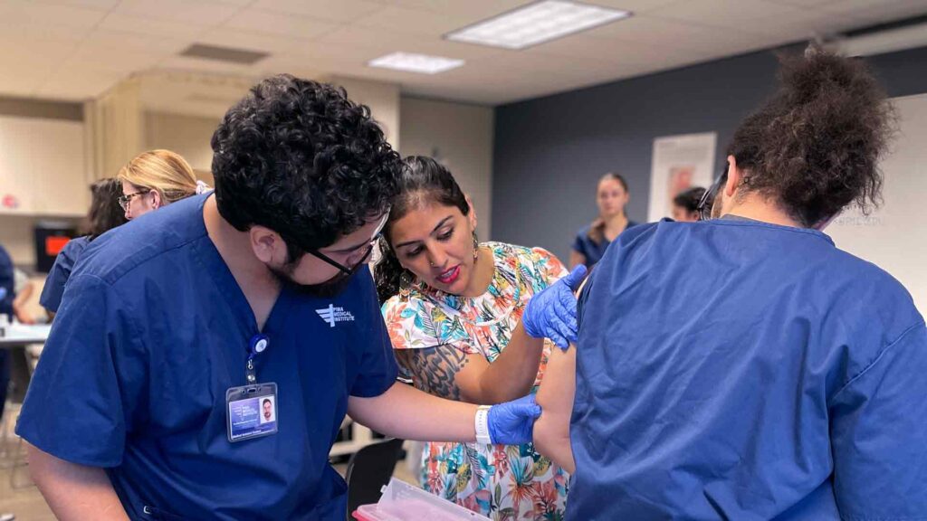 photo of medical assistant instructor teaching a student to do a patient examination
