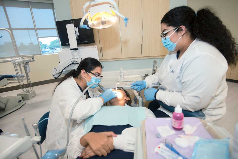 Image of students working on simulation patient in the dental assistant lab.