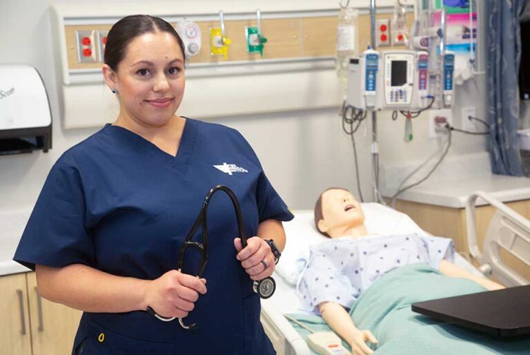 RN_student_posing_next_to_simulation_patient_with_stethescope_hero