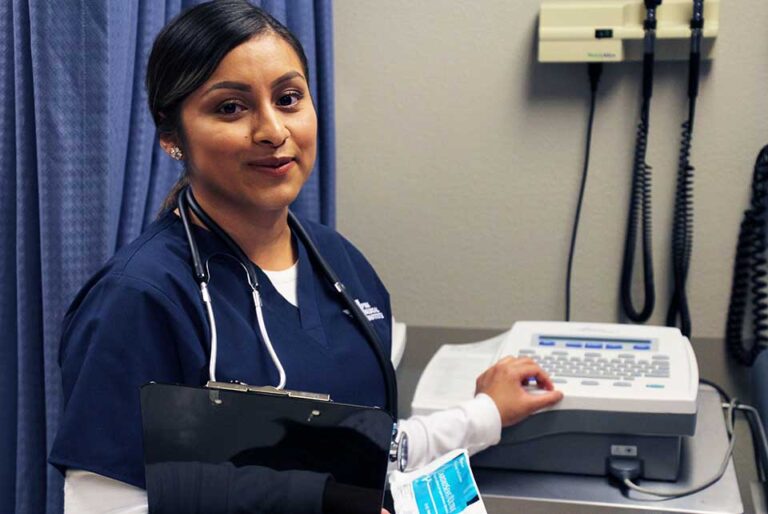 photo of a medical assistant student with a clipboard using medical equipment