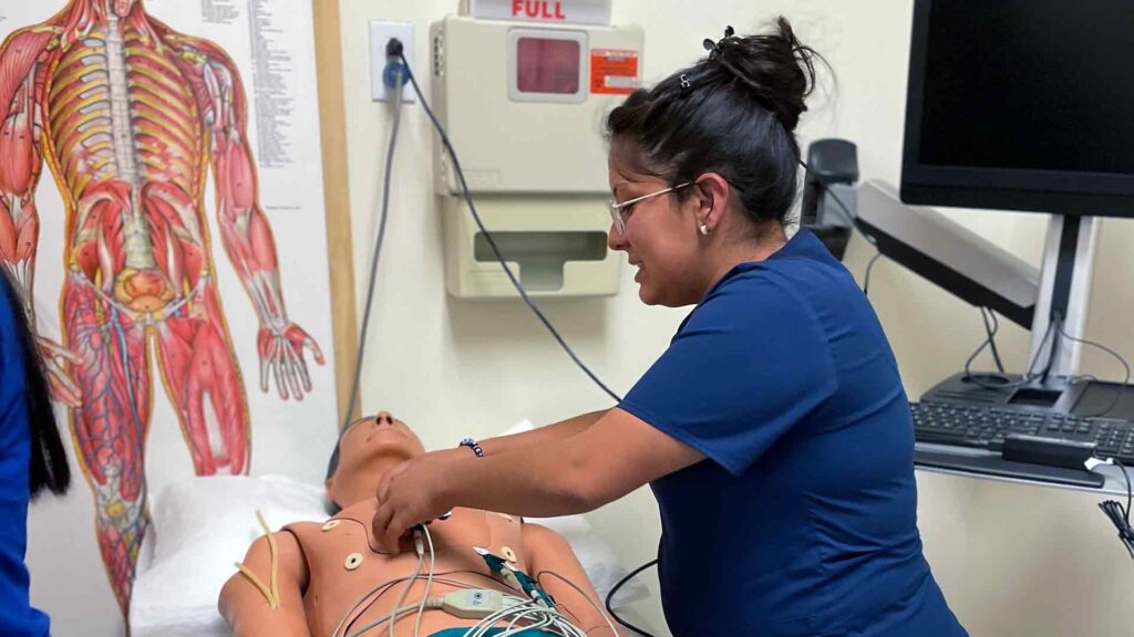 Medical Assistant student performs EKG on simulation patient during labs at the Albuquerque Campus.