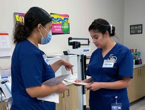 Medical Assistant students go over paperwork during a practice clinic in their lab.