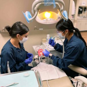 Dental Assistant students assist dentist during a filing procedure on mock patient.