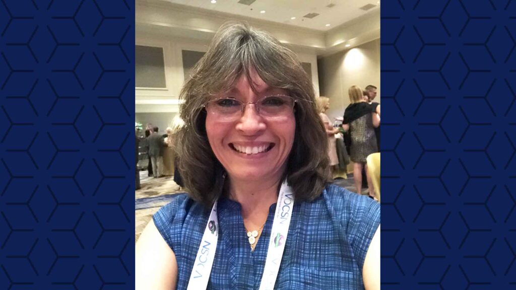 selfie of a woman with a conference in the background