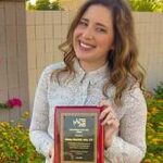 Young Woman posing and holding her award for the camera