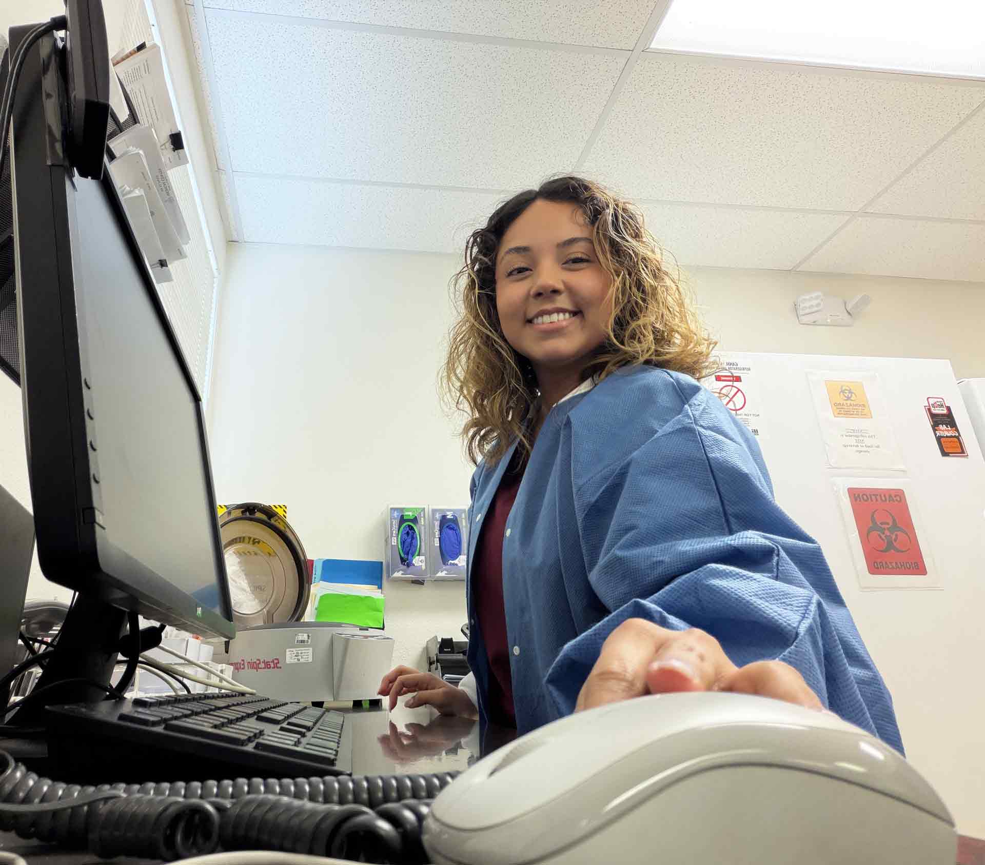 photo of Pima Medical Institute phlebotomy program graduate Angel at her desk