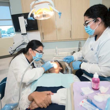 Image of students working on simulation patient in the dental assistant lab.